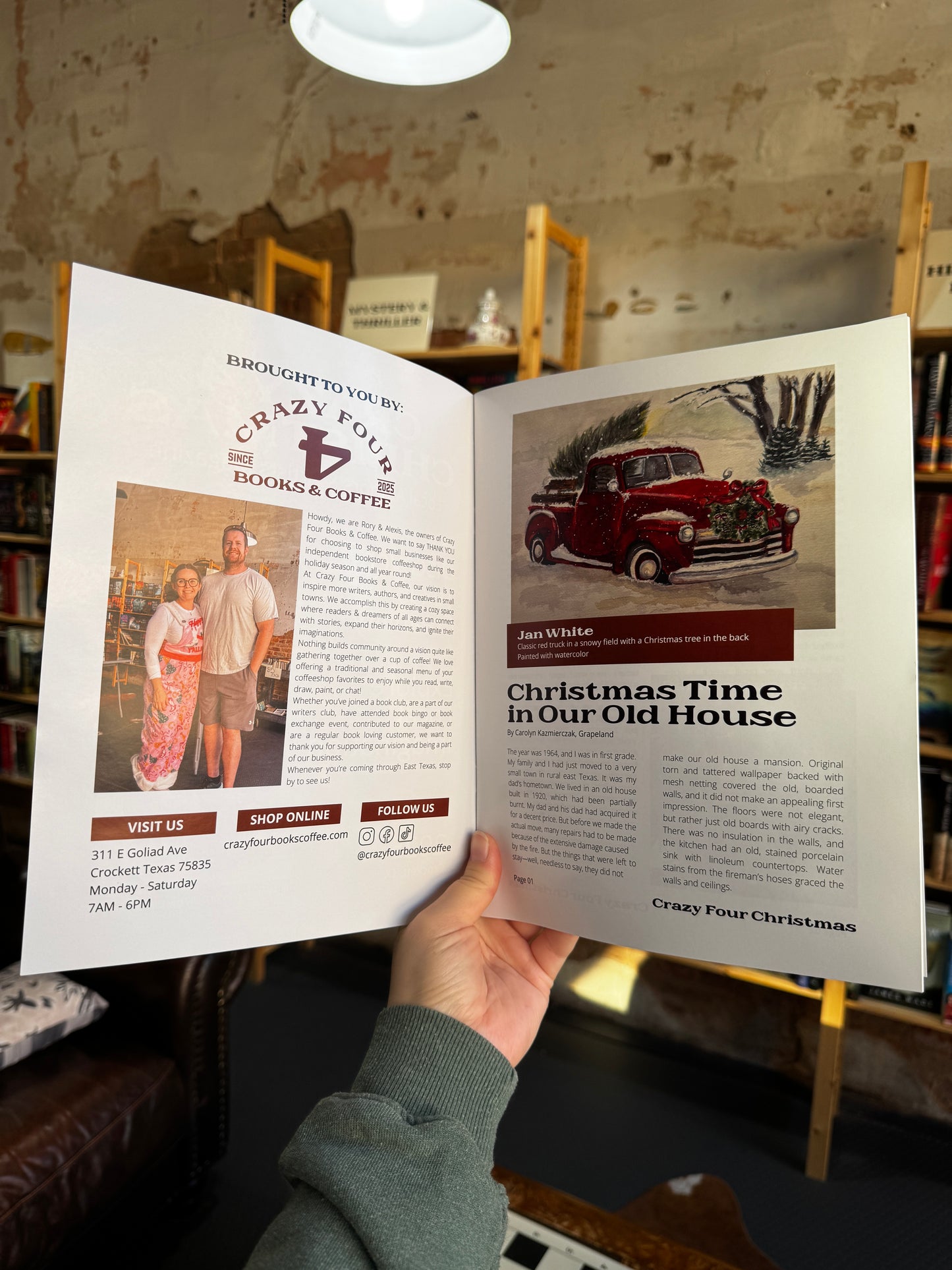 Person holding an open magazine with text and images, sitting in a room with wooden shelves.